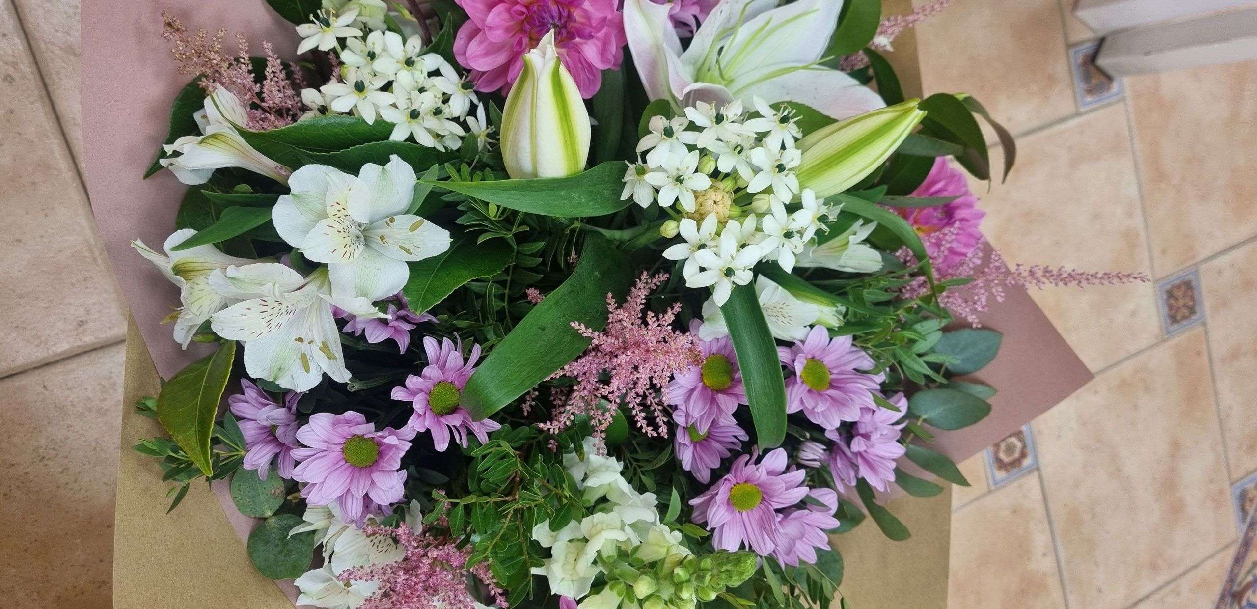 Florista seleccionando flores frescas de temporada en el taller para comparar ramos de flores de IA vs florista en Alcalá